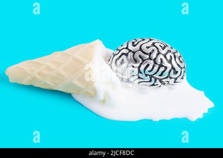 Copie anatomique en acier d'un cerveau humain placé dans une glace de cône gaufré fondu sur un fond bleu. Concept de chaleur extrême d'été. Banque D'Images