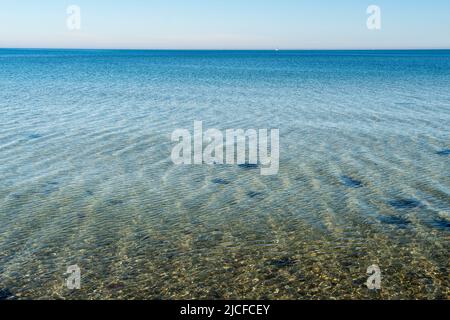 Schleswig-Holstein, embouchure de la rivière Schleim, côte près de Maasholm, structure de gravier, eau, vagues et lumière, voilier à l'horizon Banque D'Images