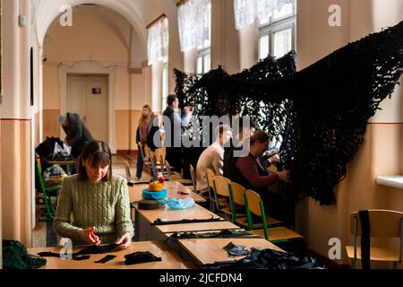 Les élèves et les enseignants nouent des filets de camouflage dans une école de Chernowitz. Les classes sont annulées. Banque D'Images