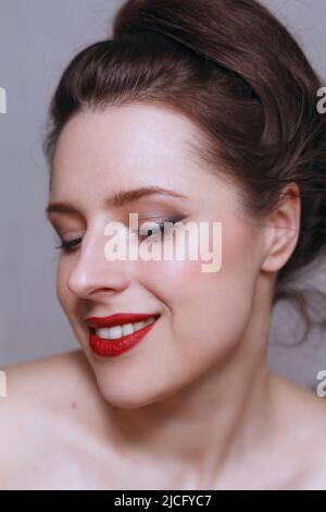 Portrait d'une femme portant un maquillage classique élégant - lèvres rouges et yeux subtilement doublés Banque D'Images