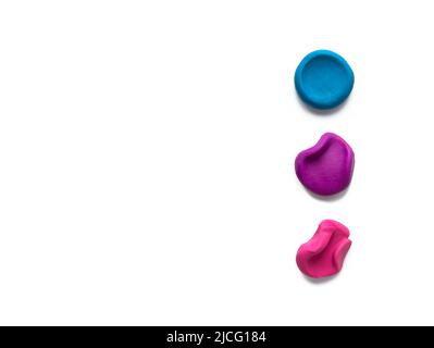 Trois couleurs modelage argile doigt plasticité texturées aplatir et crumppés boules ou morceaux isolés sur fond blanc avec ombre. Vue de dessus, copier la flèche Banque D'Images
