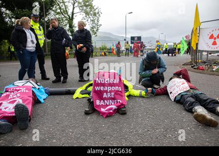 Coulport, Argyll, Écosse 13 juin 2022 cinq anciennes femmes Greenham et trois membres de Peace Pirates, une branche de Trident Ploughshares, ont organisé un blocus au magasin de têtes nucléaires de Coulport. Le «Greenham a versé du sang factice sur eux-mêmes et a mis en scène un dé-in devant les portes, bloquant un côté de l'entrée dans la base tandis que les membres de «Peace Pirates» (professeur à la retraite Brian Quail, 84, avec une greffe de coeur et handicapés par un accident vasculaire cérébral récent, Willemien Hoogendorf de Hollande et Gillean Lawrence, grand-mère et partisan de XR Peace) ont bloqué le rond-point plus loin Banque D'Images