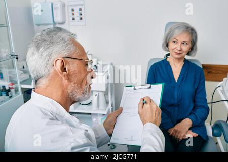 Audiologiste aux cheveux gris qui consulte une patiente âgée ayant des problèmes d'audition au centre auditif. Consultation du médecin de l'audition Banque D'Images