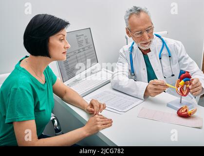 Consultation en cardiologie. Médecin cardiologue de sexe masculin consultant une patiente souffrant de problèmes cardiaques Banque D'Images