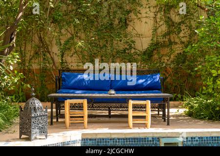 Vous pourrez vous asseoir en plein air au bord de la piscine dans le jardin intérieur d'un hôtel Riad situé à Marrakech, au Maroc. Banque D'Images