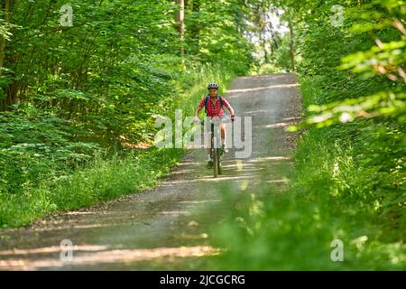 Belle femme active senior à vélo électrique dans la forêt verte de Stuttgart, en Allemagne Banque D'Images