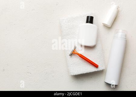 kit homme à raser. machine à raser, serviette, lotion et mousse à raser sur fond coloré. Articles de bain pour hommes vue du dessus. Banque D'Images