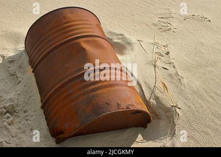 Baril rouillé sur un sable. Jeté par la mer. Obstruction des océans Banque D'Images