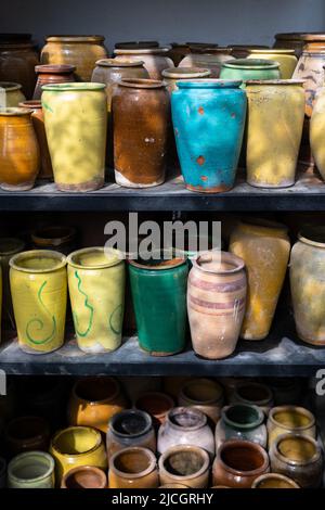 Beaucoup de cruches et vases en argile uniques et colorés faits à la main de formes diverses sur l'étagère dans le marché local Banque D'Images