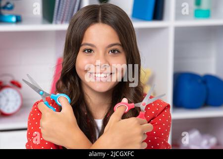 Fille d'école de l'adolescence avec des ciseaux. Idées de bricolage pour les enfants. Amour et art de l'enfant concept de passe-temps. Bonne écolière, émotions positives et souriantes. Banque D'Images