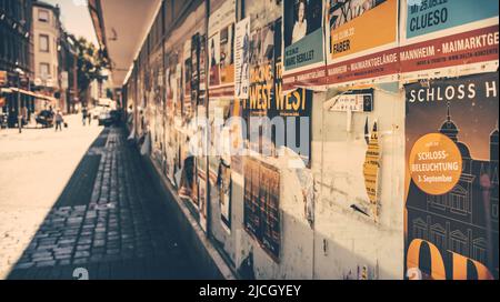 Mannheim, Allemagne - 11 juin 2022 : vieux dépliants et affiches de prévention sur une fenêtre vide de bâtiments et de magasins délabrés. Social et environnement Banque D'Images