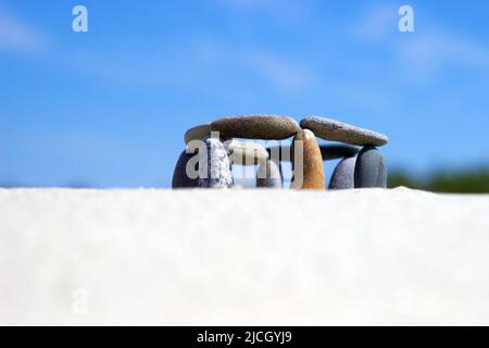 Galets équilibrés sur la côte sablonneuse. Des pierres sont empilées sur la plage. Petite stonehenge Banque D'Images