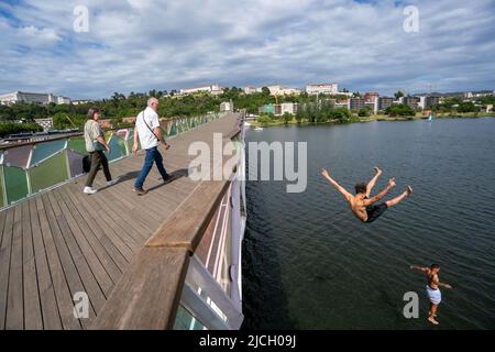 Jeunes hommes sautant sur le pont piétonnier Pedro e Inês au-dessus de la rivière Mondego à Coimbra, Portugal, Europe Banque D'Images