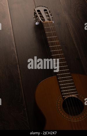 Guitare classique et tête de machine sur fond de bois sombre avec espace de copie Banque D'Images