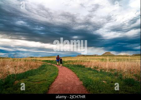 père et son fils randonnée sur un sentier de terre pendant une tempête entrante Banque D'Images