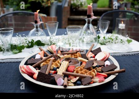 Dessert la charcuterie sur une table à dîner habillée dans le jardin Banque D'Images