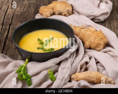 Soupe de citrouille jaune, de carottes, de gingembre et de fenouil sauvage dans un bol sombre Banque D'Images