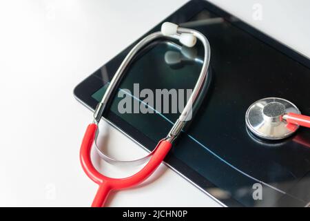 Le stéthoscope rouge sur tablette noire affiche les dossiers de santé et les dossiers de patients numériques sur la sécurité des données du cloud pour les médecins numériques et la restauration numérique Banque D'Images