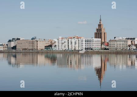 Promenade de Riga avec l'Académie lettone des sciences. Belle vue sur la Daugava avec un reflet parfait dans l'eau bleue. Banque D'Images