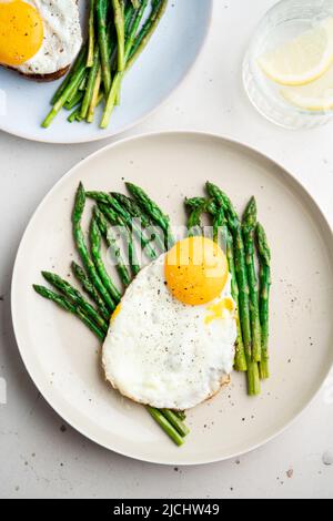 Œufs frits avec asperges vertes. Idées de déjeuner rapide, petit déjeuner sain, nourriture d'été. Banque D'Images