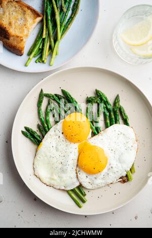 Œufs frits avec asperges vertes. Idées de déjeuner rapide, petit déjeuner sain, nourriture d'été. Banque D'Images