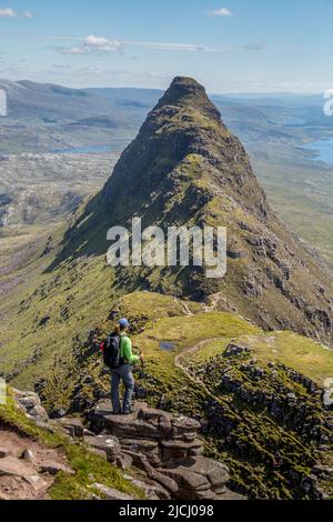 Suivlen, une montagne dans l'ouest lointain de l'Écosse. 731m haut. Une randonneur solitaire regardant vers le pic de l'Ouest, plus difficile. Banque D'Images
