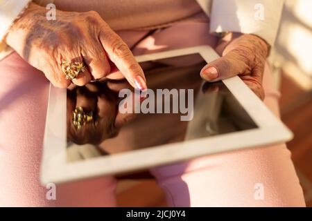 Gros plan d'une personne âgée méconnue utilisant une tablette numérique. Concept des personnes âgées et des nouvelles technologies. Banque D'Images