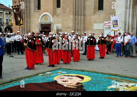 Padoue, 13 juin 2022. Fête de Saint-Antoine. Tapis de fleurs représentant Saint Anthony. Le tapis de fleurs a été fait par les artistes de la ville toscane de Fucecchio sur le chantier de la basilique. La procession quitte la basilique. Dans la photo les pèlerins sur le Camino de Santiago. Banque D'Images
