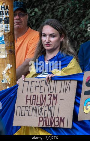 Sofia, Bulgarie, 13 juin 2022: Une femme portant le drapeau et la bannière ukrainiens nous avons vaincu le nazisme - nous allons vaincre le Raschisme, se tient à la rencontre contre R. Banque D'Images