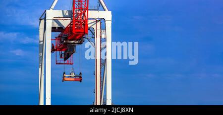 Grue portique au chantier naval grande technique lourde pour charger des conteneurs sur le fond du ciel bleu avec l'espace de copie, personne. Banque D'Images