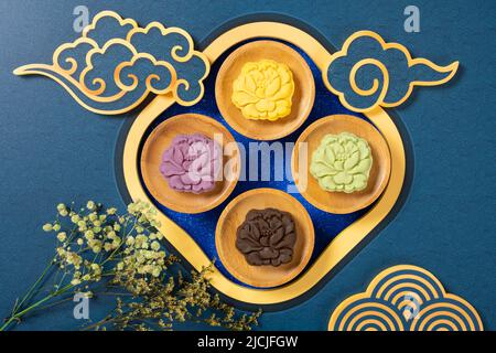 Gâteaux de lune en forme de fleur colorés et enneigés avec décorations chinoises Banque D'Images