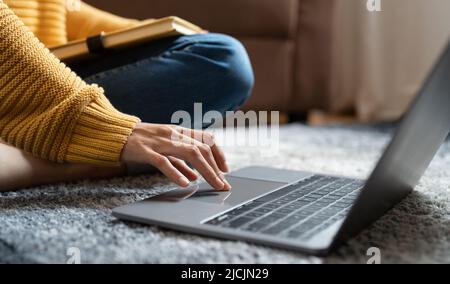 Gros plan sur les mains des femmes tout en tapant sur un ordinateur portable pour apprendre en ligne à la maison. Banque D'Images