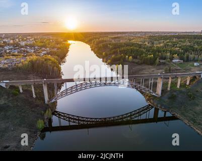 Belle vue sur le pont de chemin de fer voûté traversant la rivière Iset dans la ville de Kamenkk-Uralsky au coucher du soleil au printemps. Kamensk-Ouralskiy, Sverdlovsk reg Banque D'Images