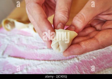 Gros plan sur la cuisson des boulettes. Les mains des femmes font des boulettes de pâte Banque D'Images