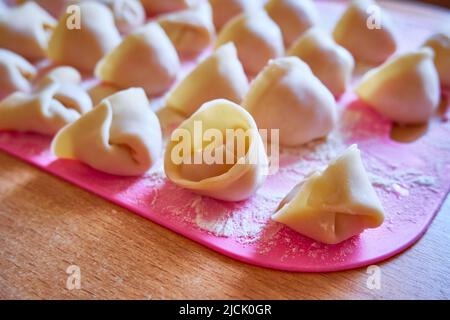 Gros plan sur les boulettes brutes. Boulettes prêtes à cuire sur un plateau rose Banque D'Images
