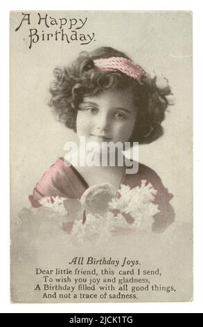 WW1 Era doux anniversaire voeux carte postale souhaitant un ami un Joyeux anniversaire. Cette carte postale teintée est d'une jeune fille, un modèle régulier pour ces types de cartes. Elle porte un bandeau et tient un bouquet de fleurs, poème sur les joies d'anniversaire, vers 1915, Royaume-Uni Banque D'Images