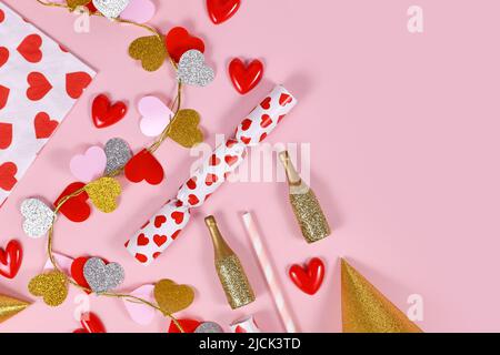 Plat de fête avec guirlande en forme de coeur, serviette, bouteilles de champagne et chapeaux de fête sur fond rose Banque D'Images