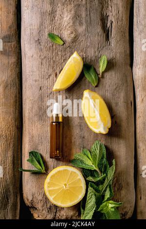 Arôme de menthe et de citron biologique essentiel ou huile cosmétique provenant d'ingrédients frais dans une bouteille en verre avec pipette. Concept promo pour soins de santé de peau et de corps an Banque D'Images