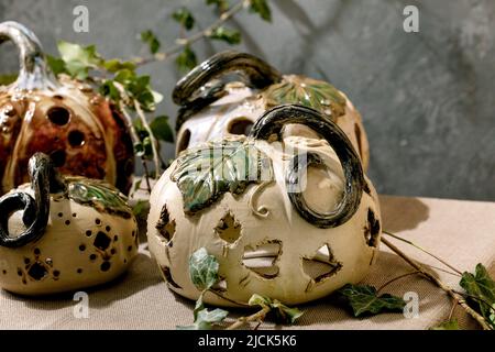 Décorations d'Halloween, ensemble de citrouilles en céramique sculptées blanches et brunes sur une table avec des feuilles de lierre. Halloween vacances intérieur maison d Banque D'Images