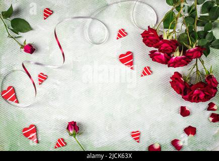 Fond festif pour la Saint-Valentin fait de roses rouges et de coeurs, de la pose plate, de l'espace de copie. Banque D'Images