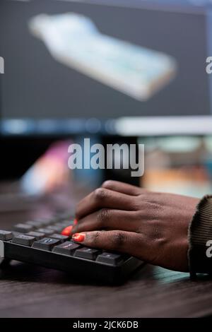 Gros plan d'un artiste créatif professionnel 3D qui développe une scène numérique à l'aide d'une technologie logicielle avancée. Chef d'équipe du service de production travaillant dans le domaine de la CAO pour créer un maillage prototype. Banque D'Images