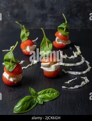 Les brochettes de tomates cerises, de mozzarella et de feuilles de basilic rappellent le tricolore du drapeau italien Banque D'Images