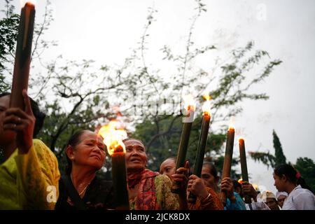 Femme plus âgée portant une torche traditionnelle pour une série d'événements célébrant le jour de Nyepi à Kediri, Eastjava, Indonésie Banque D'Images