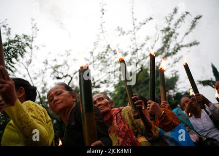 Femme plus âgée portant une torche traditionnelle pour une série d'événements célébrant le jour de Nyepi à Kediri, Eastjava, Indonésie Banque D'Images