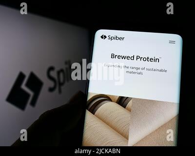Personne tenant un smartphone avec la page Web de la société japonaise de biotechnologie Spiber Inc. À l'écran devant le logo. Concentrez-vous sur le centre de l'écran du téléphone. Banque D'Images