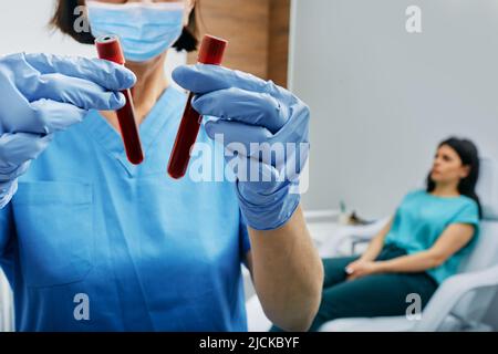 Infirmière prenant du sang pour le test des allergènes en recueillant du sang dans des tubes à essai au laboratoire. Test sanguin pour les allergies Banque D'Images