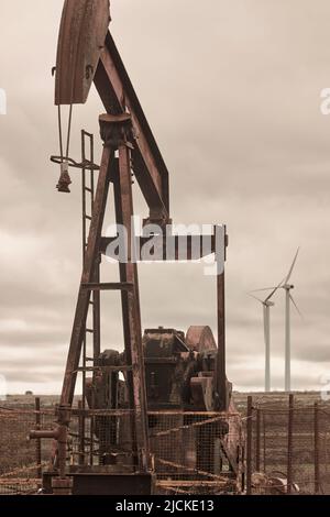 Machine de pompage d'huile et moulins à vent. Extraction de pétrole. Ressource Banque D'Images