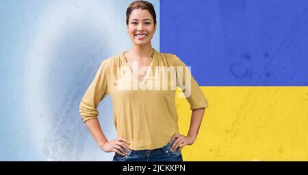 Portrait d'une femme caucasienne avec les mains sur les hanches contre l'arrière-plan du drapeau de l'ukraine Banque D'Images