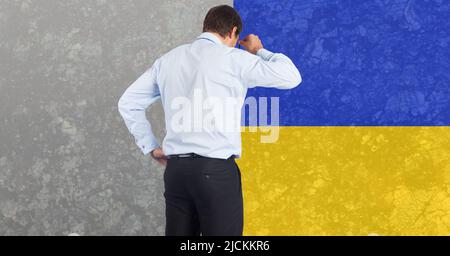 Vue arrière de l'homme d'affaires caucasien stressé contre l'arrière-plan du drapeau de l'ukraine Banque D'Images