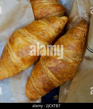Trois croissants fraîchement sortis du four sur un sac en papier, gros plan. Banque D'Images